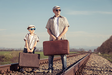 Image showing Father and son walking on the railway at the day time.