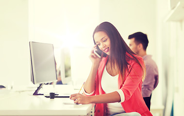 Image showing businesswoman calling on smartphone at office