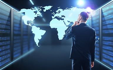 Image showing businessman with world map projection in corridor