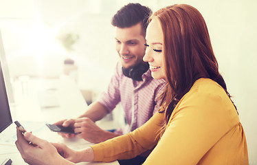 Image showing happy creative team with smartphones at office