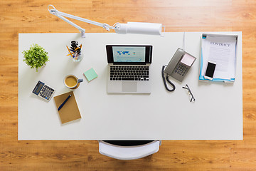 Image showing laptop, phone and other office stuff on table