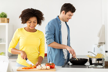 Image showing happy couple cooking food at home kitchen