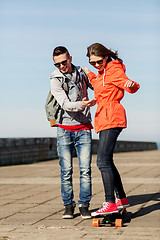 Image showing happy couple with longboard riding outdoors