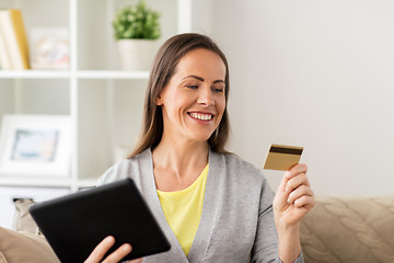 Image showing happy woman with tablet pc and bank card at home