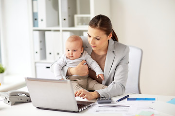 Image showing happy businesswoman with baby and laptop at office