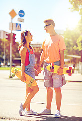 Image showing teenage couple with skateboards on city street