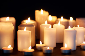 Image showing candles burning in darkness over black background