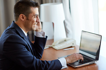 Image showing businessman with laptop and smartphone at hotel