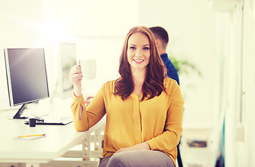Image showing happy woman drinking coffee or tea at office
