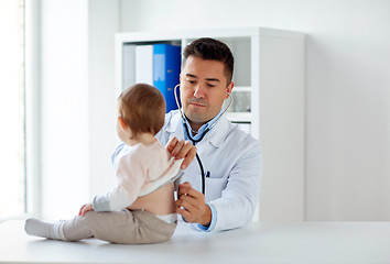 Image showing doctor with stethoscope listening baby at clinic