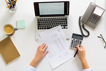 Image showing hands with calculator and papers at office table