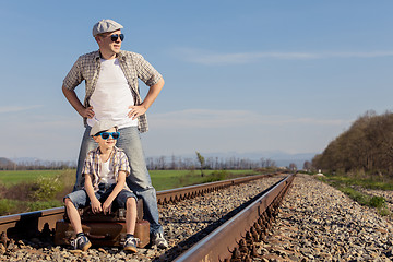 Image showing Father and son walking on the railway at the day time.