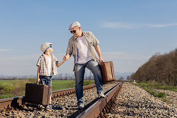 Image showing Father and son walking on the railway at the day time.