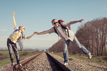 Image showing Father and daughter walking on the railway at the day time.
