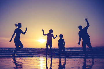 Image showing Silhouette of happy family who playing on the beach at the sunse