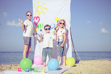 Image showing Two sisters and brother playing on the beach at the day time.