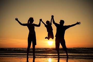 Image showing Silhouette of happy family who playing on the beach at the sunse