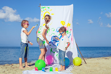 Image showing Two sisters and brother playing on the beach at the day time.