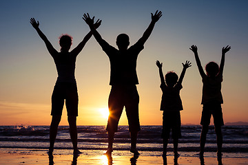 Image showing Silhouette of happy family who playing on the beach at the sunse