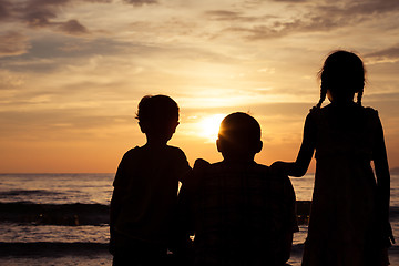 Image showing Father and children playing on the beach at the sunset time.