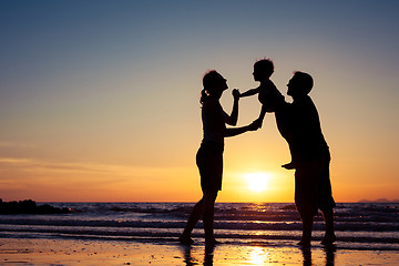 Image showing Silhouette of happy family who playing on the beach at the sunse