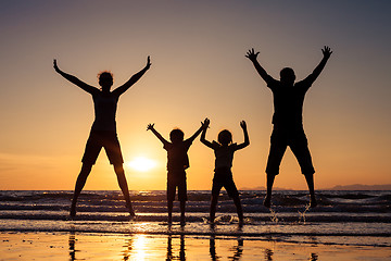 Image showing Silhouette of happy family who playing on the beach at the sunse