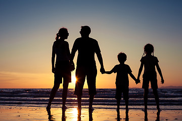 Image showing Silhouette of happy family who playing on the beach at the sunse