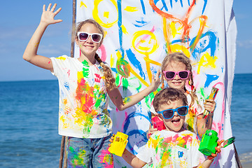 Image showing Two sisters and brother playing on the beach at the day time. 