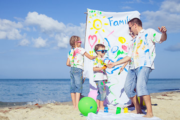 Image showing Father and children playing on the beach at the day time.