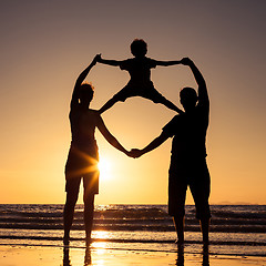 Image showing Silhouette of happy family who playing on the beach at the sunse