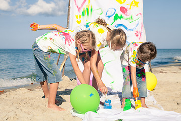 Image showing Two sisters and brother playing on the beach at the day time.