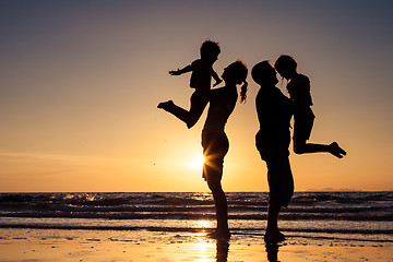 Image showing Silhouette of happy family who playing on the beach at the sunse