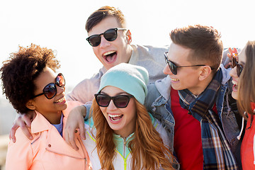 Image showing happy teenage friends in shades laughing outdoors