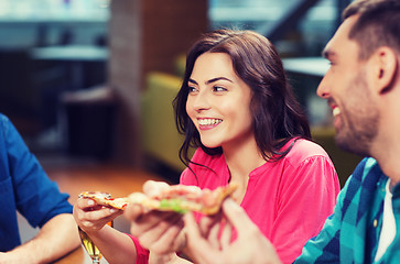 Image showing friends eating pizza with beer at restaurant