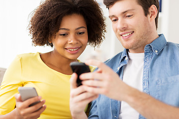 Image showing happy couple with smartphones at home