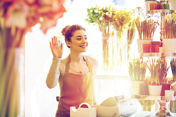 Image showing smiling florist woman at flower shop cashbox