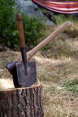 Image showing Stump with axe and shovel at camping