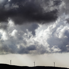 Image showing Silhouette of wind farm and overcast cloudy sky before storm