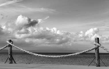 Image showing Black and white view on seafront and sky with sunlight clouds in