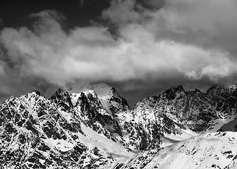 Image showing Black and white view on high snowy mountains in clouds at sunny 