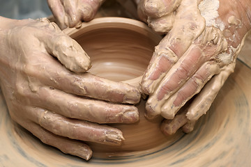 Image showing Women hands in clay at process of making  crockery on pottery wh