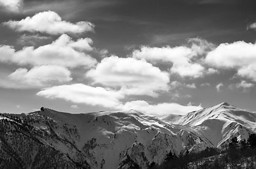 Image showing Black and white view on sunlight snow mountains and sky with clo