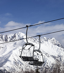 Image showing Chair lift in snowy mountains at nice sun day