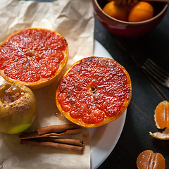 Image showing Baked apples and grapefruit at wooden table