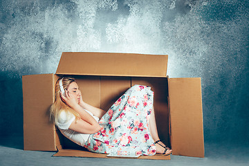 Image showing Introvert concept. Woman sitting inside box and working with laptop