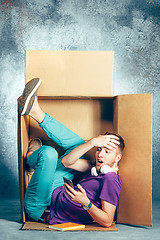 Image showing Introvert concept. Man sitting inside box and working with phone