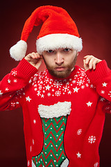 Image showing Surprised christmas man wearing a santa hat