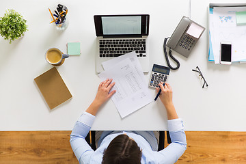 Image showing businesswoman with tax report at office