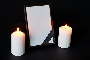 Image showing black ribbon on photo frame and candles at funeral