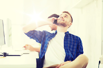 Image showing happy creative man calling on cellphone at office